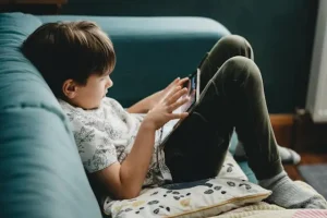 Padre ayudando a su hijo a usar una tablet en casa