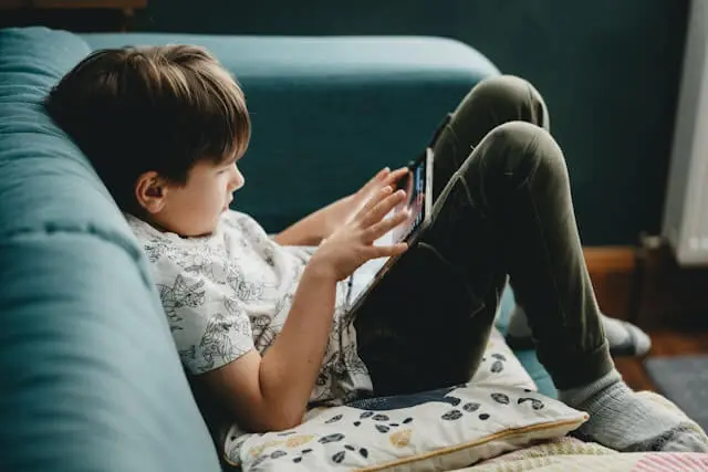 Padre ayudando a su hijo a usar una tablet en casa